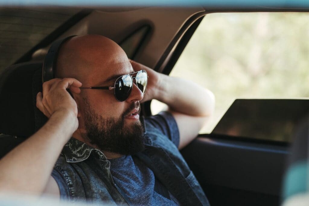 The car passenger is listening music through headset